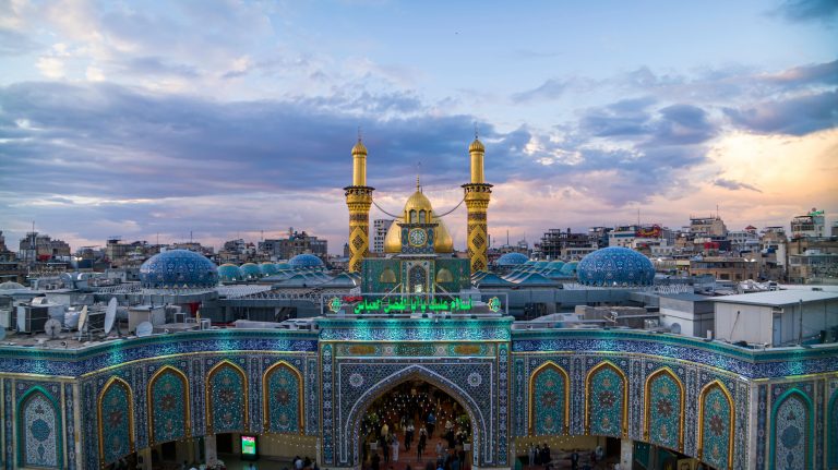 A stunning aerial view of the Imam Hussain Shrine in Karbala, featuring golden domes and vibrant architecture.